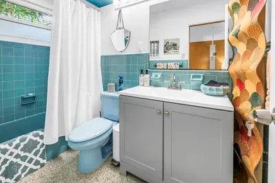Bright retro bath with blue tile, modern vanity, and cheerful style