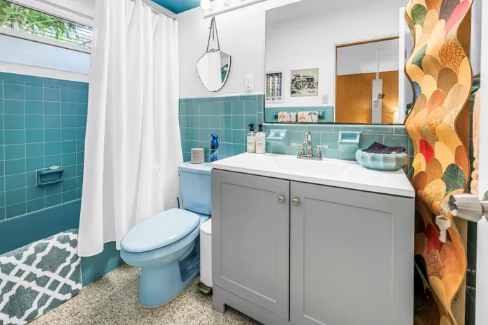 Bright retro bath with blue tile, modern vanity, and cheerful style