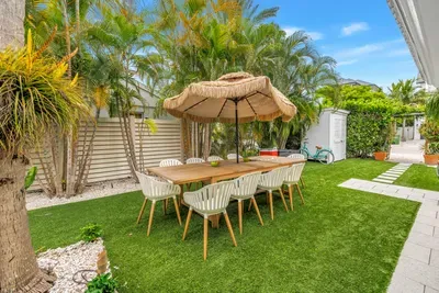 Tropical backyard dining oasis with shaded seating for the whole group