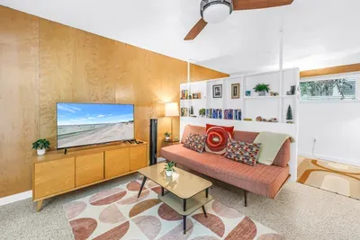 Bright mid-century living room with cozy seating and smart TV