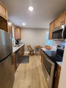 Well stocked galley kitchen with small table and 2 chairs for meals in.