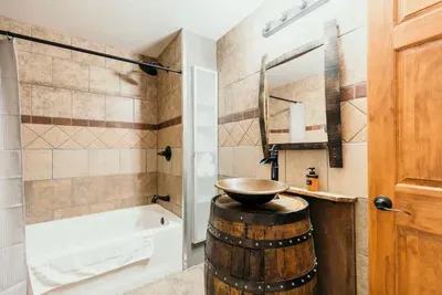Whiskey barrel sink with a copper bowl produced by a local craftsman in the lower level bathroom.