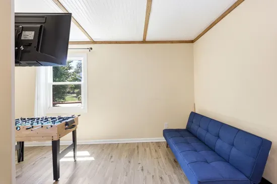 Bright game room with foosball table and blue futon seating
