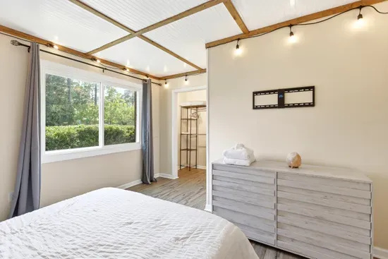 Bright, airy bedroom with nature views, warm accents, and ample storage