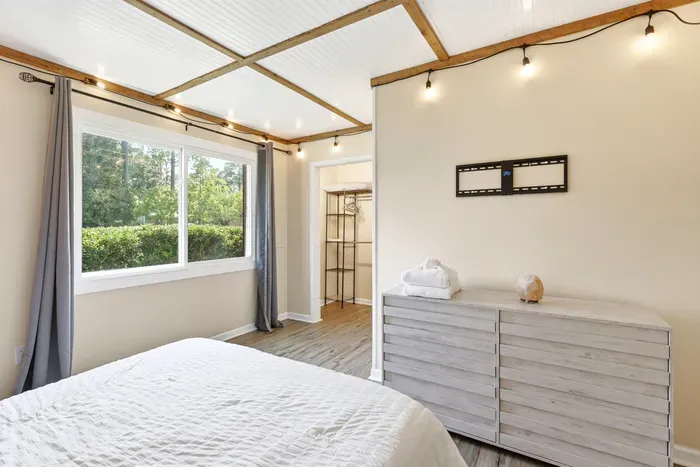 Bright, airy bedroom with nature views, warm accents, and ample storage