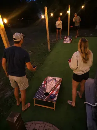 String-lit cornhole court for fun evening hangouts outdoors