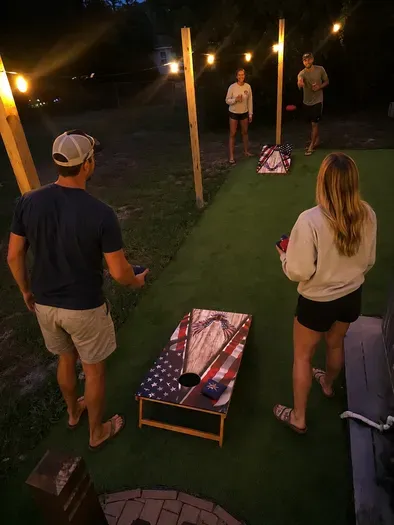 String-lit cornhole court for fun evening hangouts outdoors