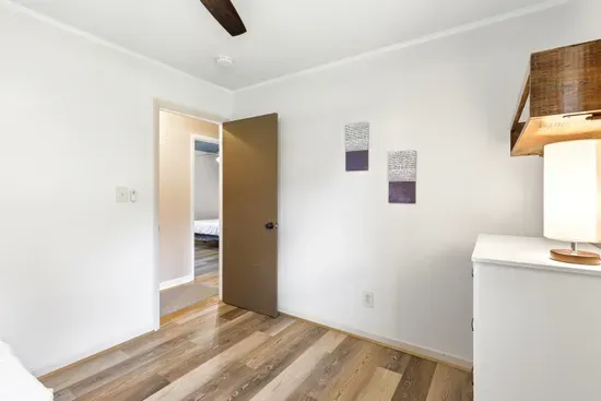 Bright, minimalist bedroom with wood floors and convenient storage