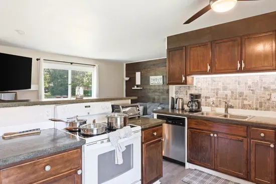 Bright open kitchen with wood cabinets, full appliances, and natural light