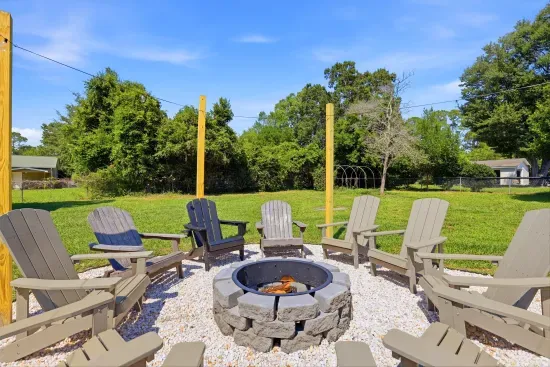 Spacious backyard fire pit with Adirondack seating for cozy evenings