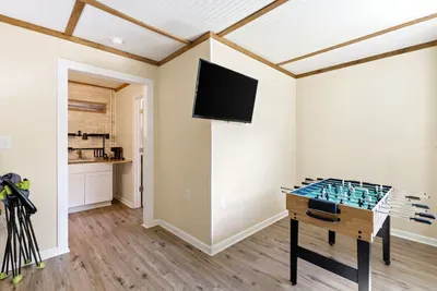 Fun game room with foosball, TV, and nearby wet bar area
