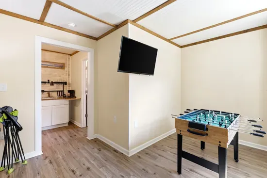 Fun game room with foosball, TV, and nearby wet bar area