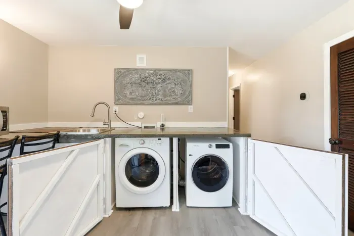 Convenient in-home laundry with sink, folding counter, and stylish barn doors