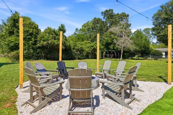 Cozy backyard fire pit with Adirondack seating and string lights