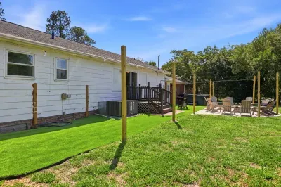 Spacious backyard with deck, turf lawn, and cozy fire pit seating area