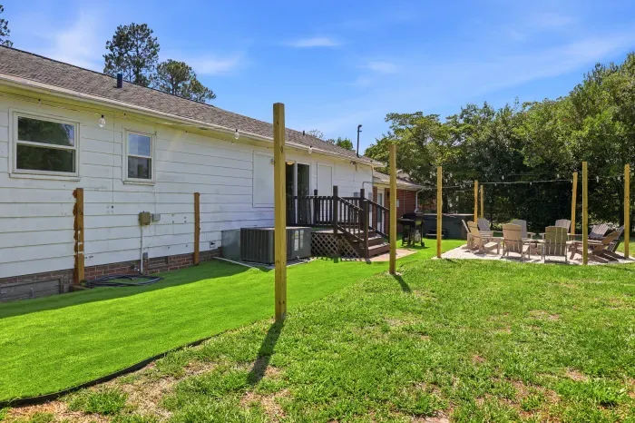 Spacious backyard with deck, turf lawn, and cozy fire pit seating area
