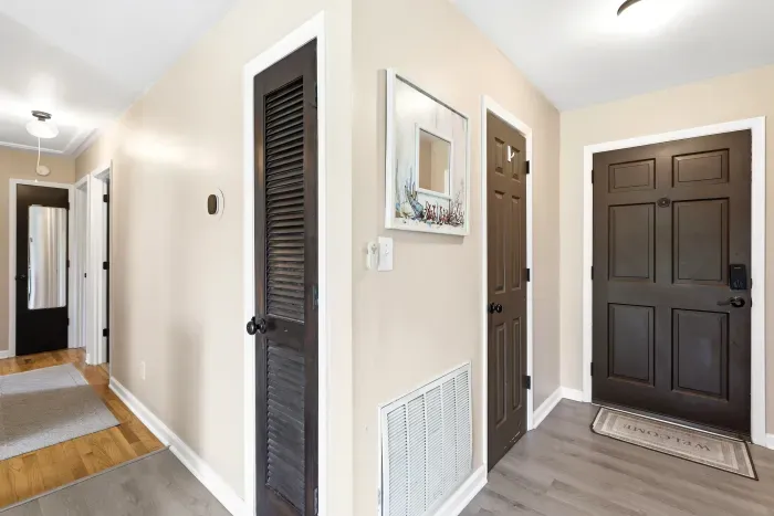 Bright, welcoming entryway with stylish dark wood doors and closet storage