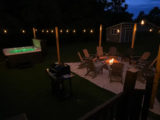 Relax under string lights with a hot tub, fire pit, and cozy outdoor seating