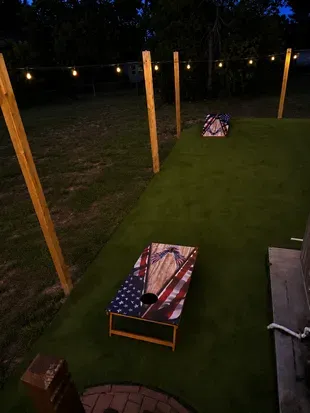 Lighted backyard cornhole area for fun outdoor evenings