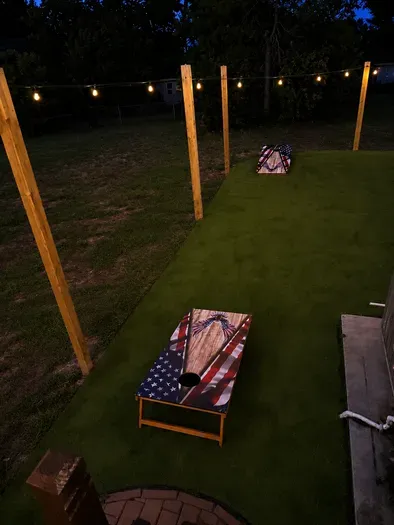 Lighted backyard cornhole area for fun outdoor evenings