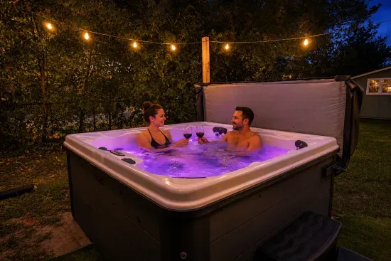 Private backyard hot tub under string lights for a relaxing evening soak