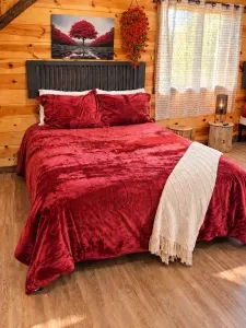 Cozy cabin bedroom with plush velvet bedding and warm rustic charm