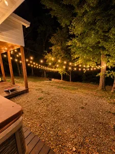 Cozy lit backyard with string lights and hot tub retreat