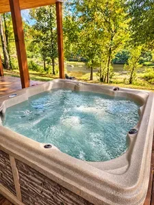 Private riverside hot tub with peaceful wooded views