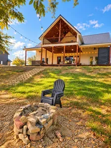 Inviting cabin retreat with string-lit porch, balcony, and fire pit