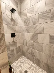 Spa-style walk-in shower with modern black fixtures and elegant tile