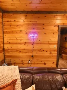 Cozy cabin lounge with rustic wood walls and fun neon accent