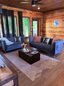 Cozy wood-lined lounge with plush seating and bright natural light
