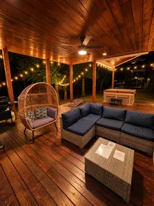 Cozy covered deck with string lights, hot tub, and stylish lounge seating