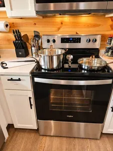 Modern kitchen with stainless range, cookware, and warm wood accents
