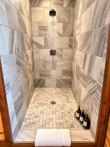 Spa-like walk-in shower with rainfall head and elegant stone tile