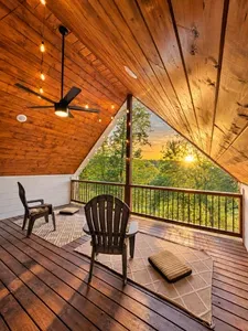 Covered A-frame deck with sunset views, string lights, and cozy seating