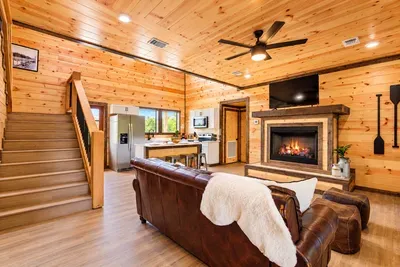 Cozy wood cabin with fireplace, vaulted ceilings, and open living space