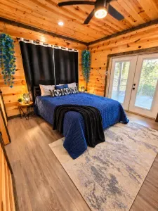 Cozy wood-paneled bedroom with plush king bed and private French doors