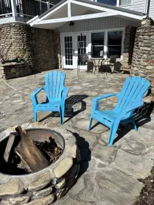 Stone patio with fire pit, Adirondack chairs, and cozy covered seating