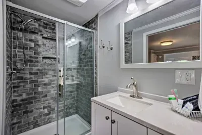 The beautifully-renovated bathroom features a full-length shower with detachable shower head, provided shampoo/conditioner/body wash, and towels. 