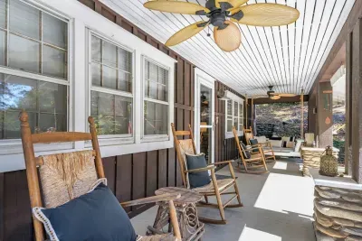 Enjoy the cooling air of ceiling fans on the covered front porch; Sit and relax on one of four rocking chairs or a swinging bench. 