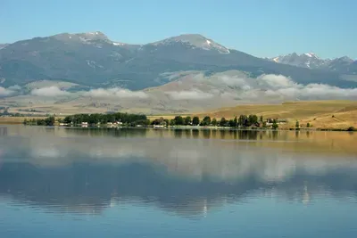 Ennis Lake is a peaceful spot, perfect for fishing, kayaking, paddleboarding, or simply soaking in views of the Madison Range. Early mornings are especially calm, with glassy water & mountain reflections. 38 miles from The Cabins at Wheat Ridge Farm.