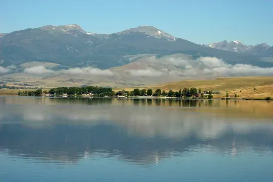 Ennis Lake is a peaceful spot, perfect for fishing, kayaking, paddleboarding, or simply soaking in views of the Madison Range. Early mornings are especially calm, with glassy water & mountain reflections. 38 miles from The Cabins at Wheat Ridge Farm.