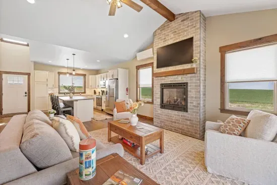 Cozy living room with Bridger Mountain views, a queen Slofa Sleeper, and a gas fireplace. The perfect place to relax after a day exploring Yellowstone or downtown Bozeman.