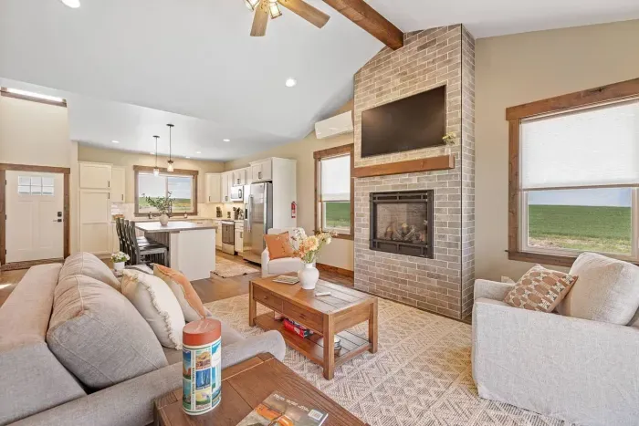 Cozy living room with Bridger Mountain views, a queen Slofa Sleeper, and a gas fireplace. The perfect place to relax after a day exploring Yellowstone or downtown Bozeman.