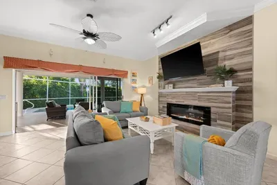 Living Room: Bright and airy space with a stylish fireplace and poolside views awaits your relaxation!