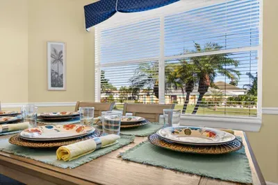 Dining Area: Savor delicious meals with palm tree views in this inviting space!