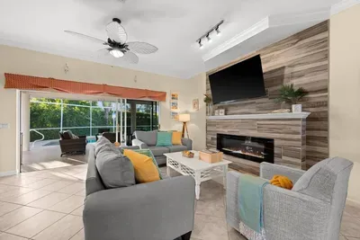 Living Room: Bright and airy space with a stylish fireplace and poolside views awaits your relaxation!