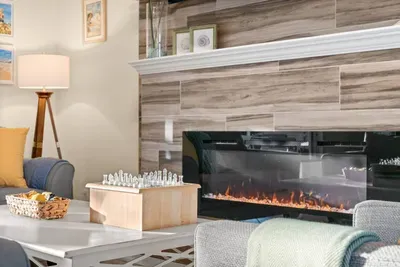 Living Room: Enjoy game nights by the glowing fireplace and modern decor in this stylish retreat!