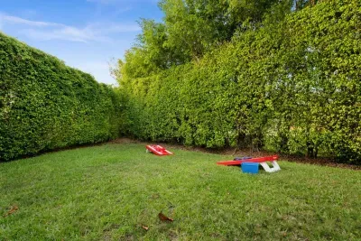 Outdoor Oasis: Enjoy friendly competitions on the lawn with cornhole and lush green privacy!